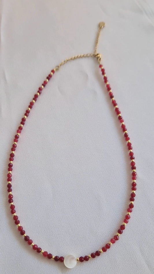 Collar de piedras rojas con detalles en acero inoxidable, un destello de energía que enciende tu presencia.