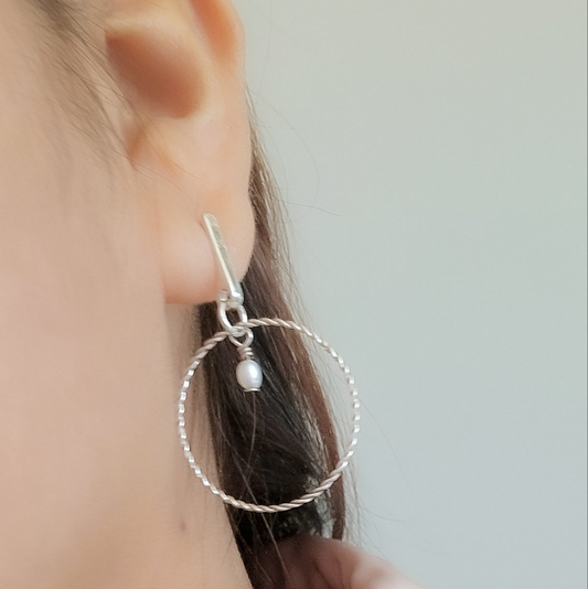 Elegancia atemporal en cada movimiento.
Nuestros pendientes "Luz Serena" combinan la suavidad natural de la perla con la forma clásica del aro, creando una joya que resalta tu feminidad con sutileza y estilo.